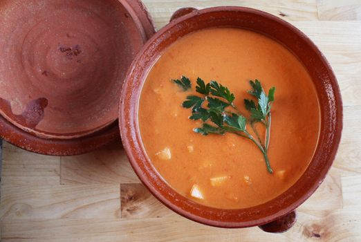 Andalusian gazpacho in a clay pot. It is a cold Spanish tomato-based raw vegetable soup and consumed during summer months due to its refresing qualities.