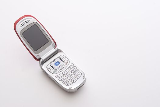 Red and silver cellular phone open with a blank screen