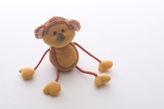 orange monkey toy with strings for arms