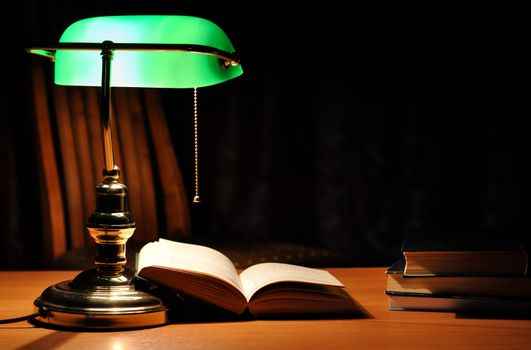Electric green table lamp and opened book