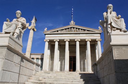 Neoclassical Academy of Athens in Greece showing main building and statues of ancient Greek philosophers Plato (left), Socrates (right) and goddess Pallas Athena (behind Plato). The Academy of Athens is the highest research establishment in the country and one of the major landmarks of the city.