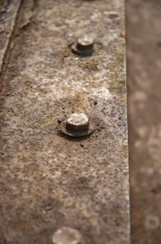 Some old rusty nuts on metal