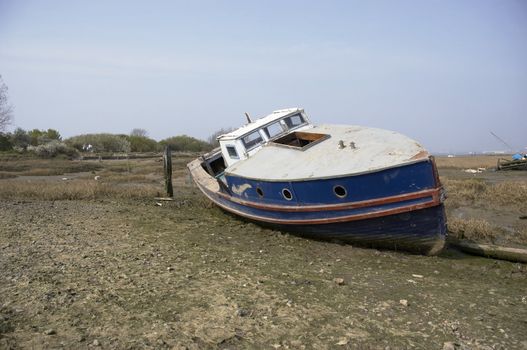 A small boat in the mud of a river estuary