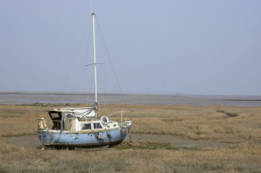 A small yacht in the mud at low tide