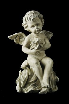 Cherub with dramatic side lighting on a black background.