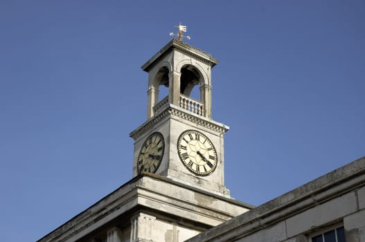 A clock tower with a weather vein on top