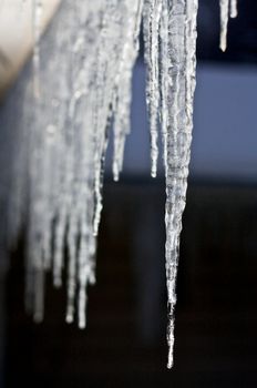 Icicles hang from a rood dormer on a winter evening