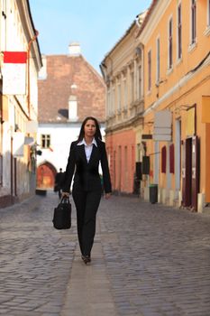 Young businesswoman walking in a traditional city street.