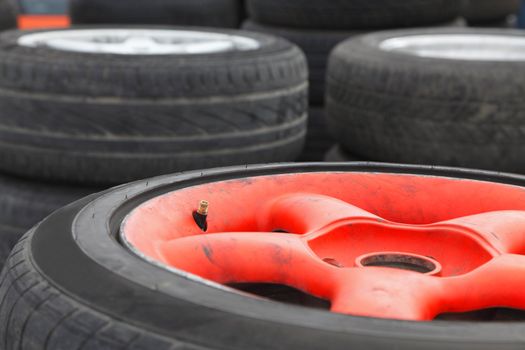 Image of a heap of race car wheels. Slective focus on the tyre valve. 