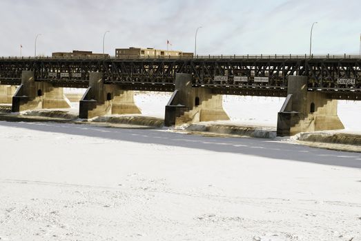 An open dam with flowing water during the winter with the rest of the river frozen.