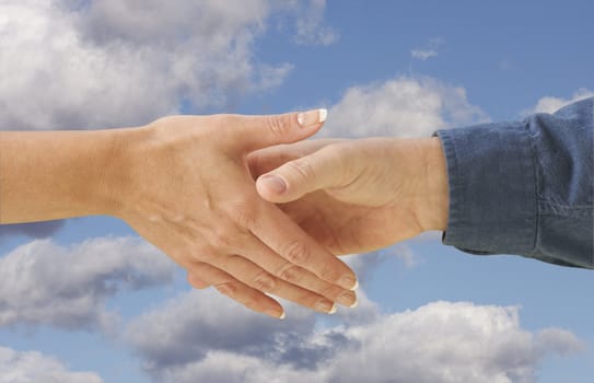 Man and woman shaking hands on cloud filled blue sky background with clipping path.