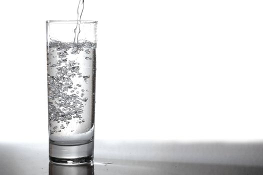glass of pouring fresh and cold water