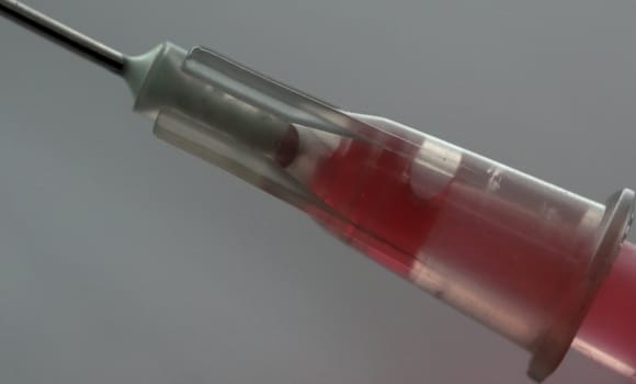 macro of syringe needle with red liquid