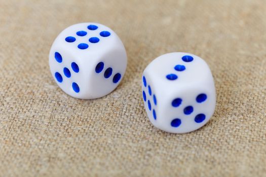 Two dice on the surface of coarse linen