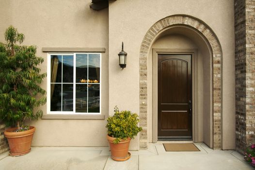 A newly constructed, modern american home doorway and patio.