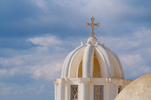 Close-up of dome and cross from Santorini, Greece on a summer day.