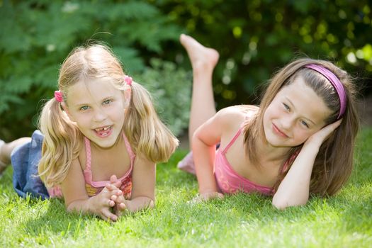 Cute young girls on a summer's day lying in the grass