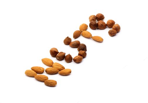 Word NUTS made from cashew and hazelnut on white background