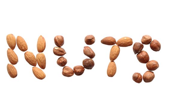 Word NUTS made from cashew and hazelnut on white background. Isolated with clipping path