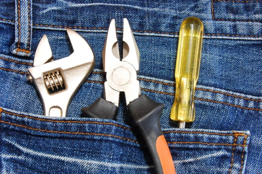 tools like caliper screwdriver and spanner in jeans pocket
