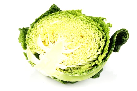 Half a raw green cabbage on a reflective white background