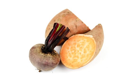 Sweet Potato cut in half with a small uncooked beetroot on a reflective white background