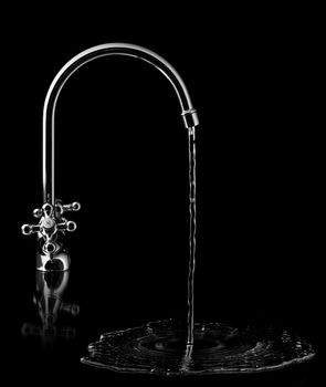 Water tap on black background