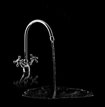 Water tap on black background