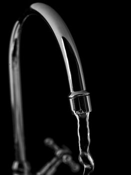 Tap with water on black background