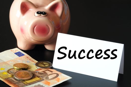 financial success concept with piggy bank on black background