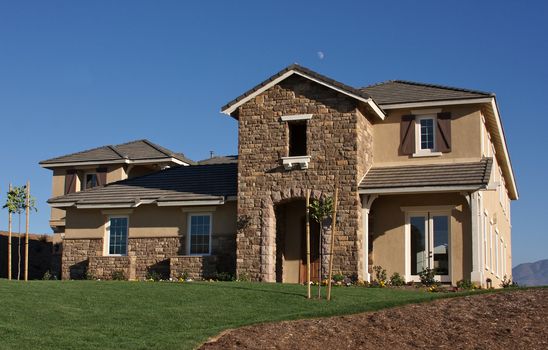 A newly constructed, modern american home with fresh landscaping.