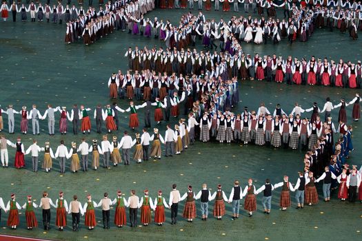 RIGA - JULY 9: Dancers in traditional costumes perform at the dress rehearsal of Grand Dance Performance during the Latvian Nationwide Song and Dance Celebration in Riga, Latvia, 9 July, 2008