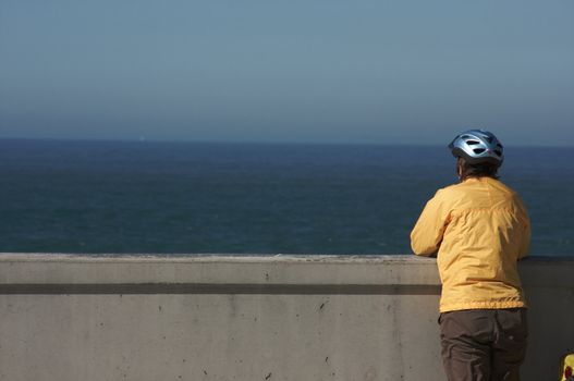 Bicyclist Rests Overlooking the Pacific Ocean