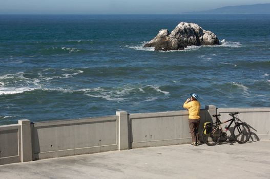 Bicyclist Rests Overlooking the Pacific Ocean