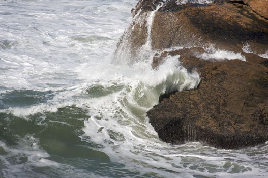 Pacific Ocean Waves break against the rocks.