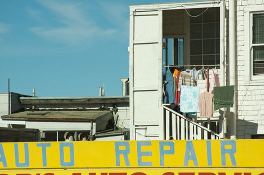 Abstract of Upper Aprtment Entry with Clothing Drying and Auto Repair Sign.