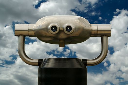 Modern looking Telescope in a Public Area with beautiful blue sky and dramatic clouds.