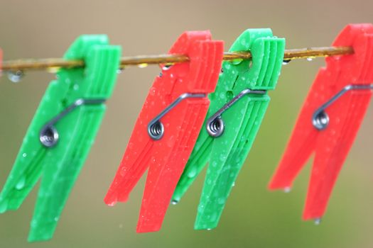 4 Washing pegs clipped to a washing line with rain drops