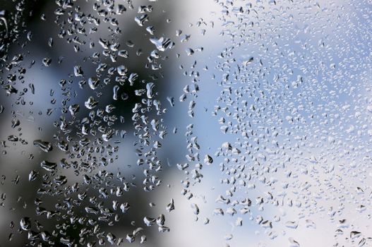 Rain Drops on Window as the clouds clear behind.