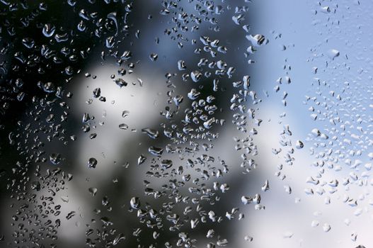 Rain Drops on Window as the clouds clear behind.