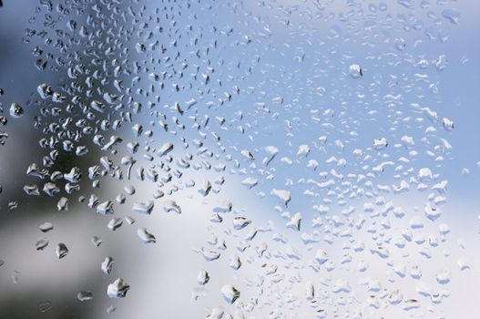 Rain Drops on Window as the clouds clear behind.