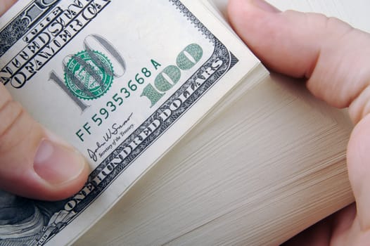 Man Fanning Large Stack of One Hundred Dollar Dollar Bills