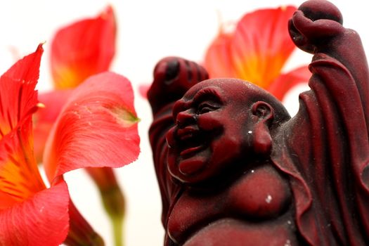 Red Buddha statue with red Peruvian lilies