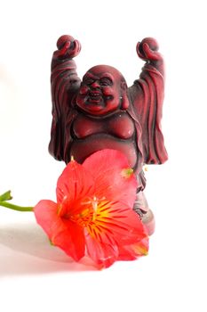 Red Buddha statue with red Peruvian lilies