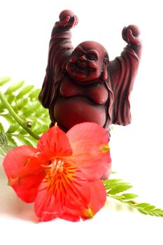 Red Buddha statue with red Peruvian lilies