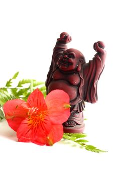Red Buddha statue with red Peruvian lilies