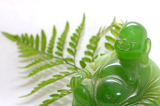 Green buddha with leaves and flowers