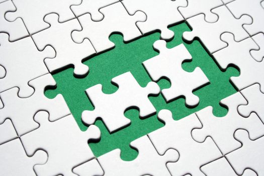 White jigsaw pieces on a green background