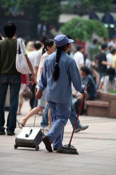 Woman cleaning the street in China