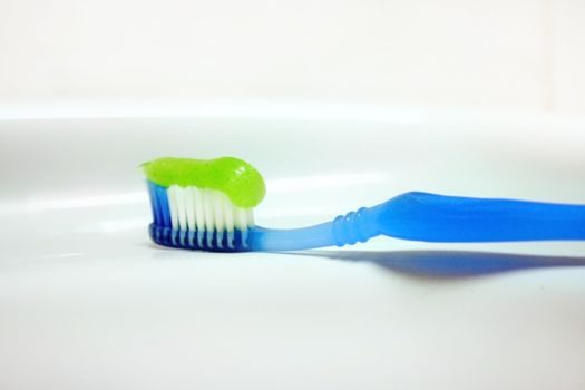 toothbrush with paste for cleaning teeth on background of the washstand